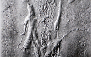 Striding divine figure with sickle sword (scimitar)